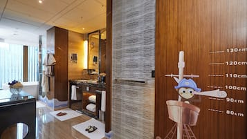 A modern bathroom with a wooden vanity, a mirror, and a towel rack.