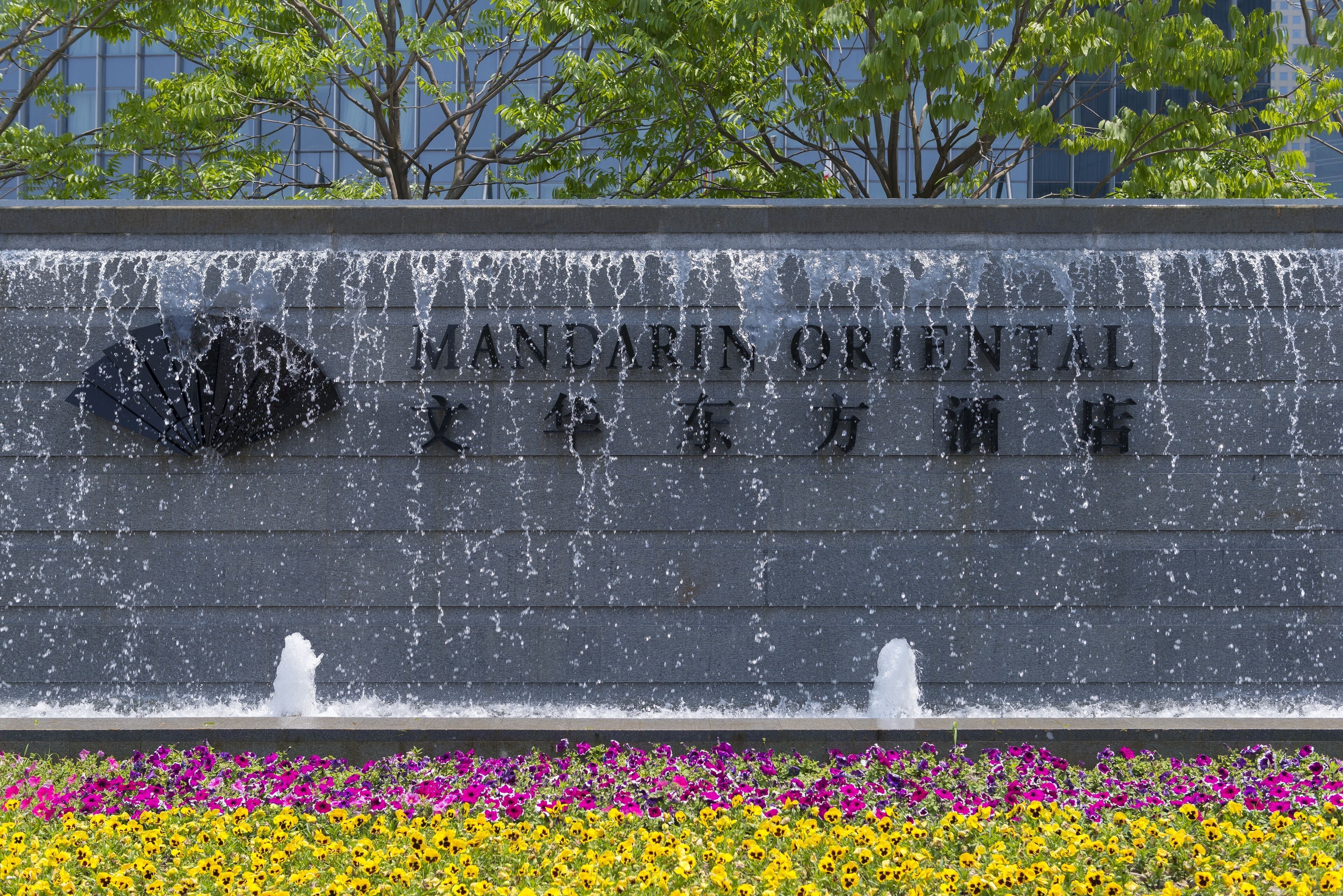 Une fontaine avec des jets d’eau et une plaque portant l’inscription « MANDARIN ORIENTAL ».