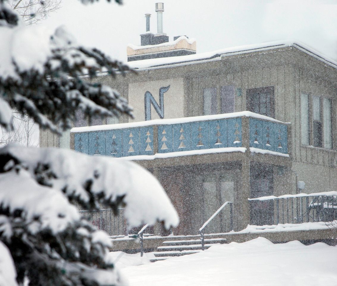 A building with a prominent 'N' on the facade, surrounded by snow.
