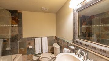 Een badkamer met toilet, wastafel en bad.