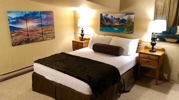 Una habitación de hotel con una cama grande, dos mesitas de noche y dos lámparas de pared.