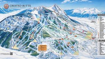 A detailed ski resort map with marked ski runs, lifts, and terrain features.