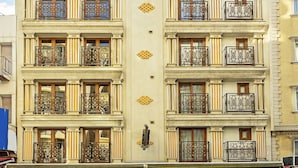 A multi-story building with balconies, large windows, and a ground-level restaurant with outdoor seating. - Septimum (Istanbul)