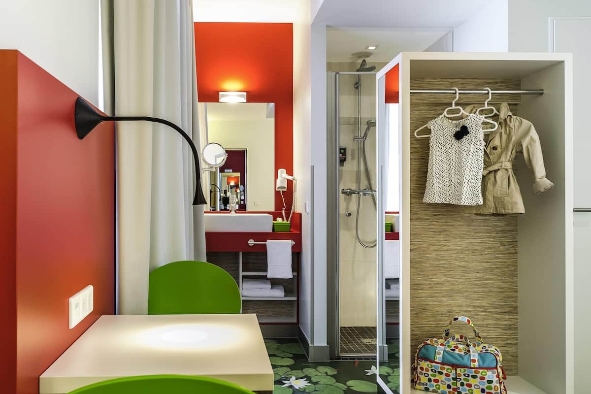 Een moderne badkamer met een douche, een wastafel met spiegel en een handdoekhouder.