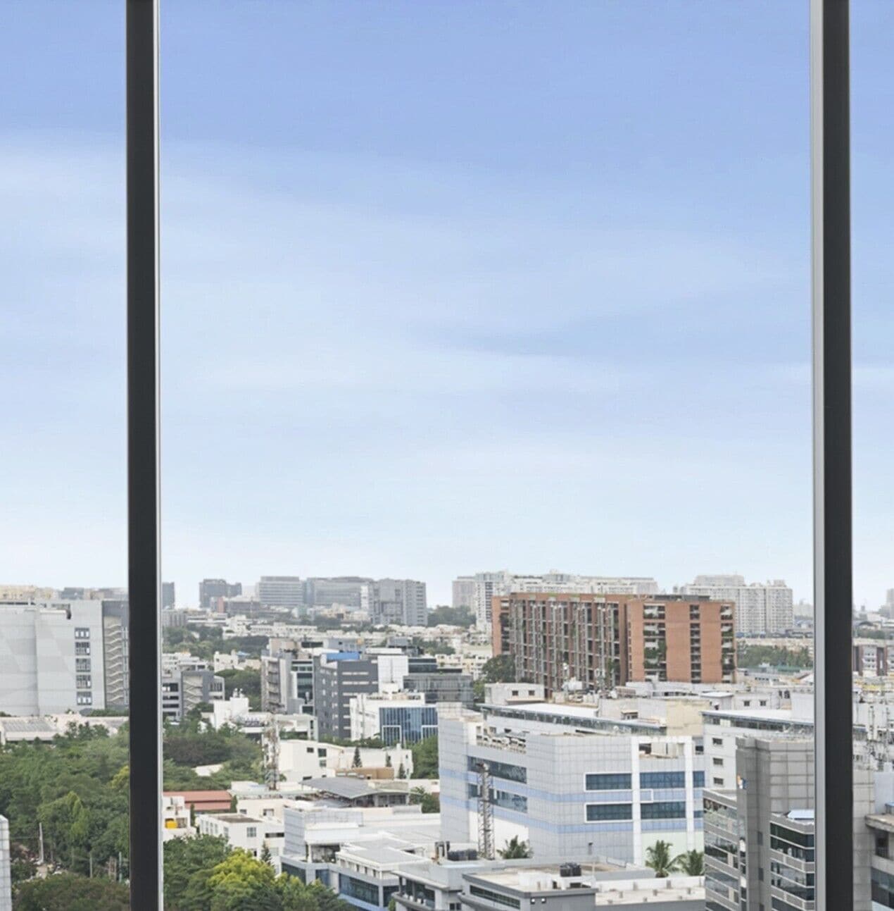 Vista da cidade a partir de um arranha-céu, com vários edifícios e céu claro.