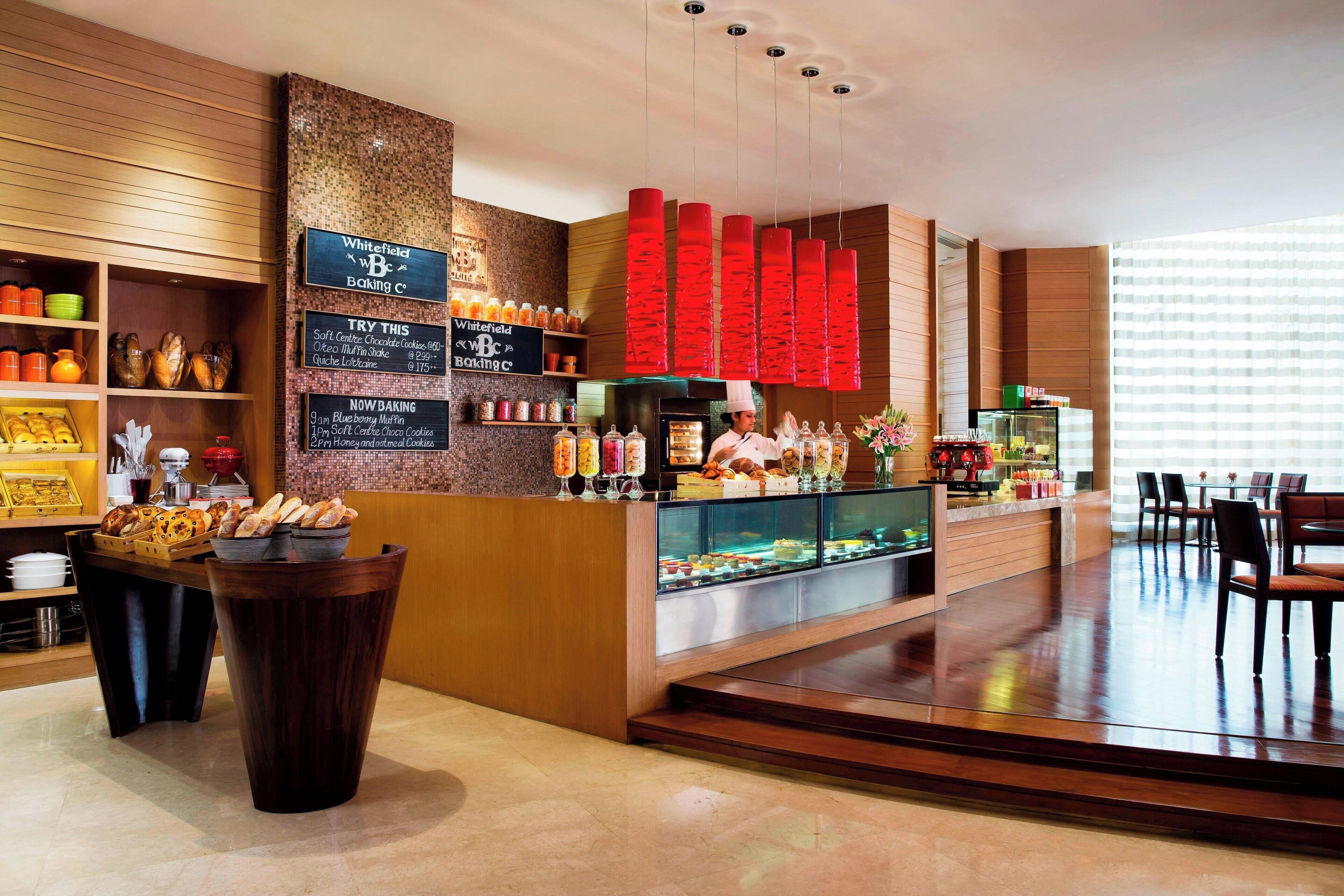 A bakery counter with various baked goods and a menu board.