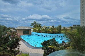 Una piscina rodeada de palmeras y un edificio con techo de tejas.