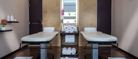 A modern bathroom with two sinks, a mirror, and a shelf with toiletries.