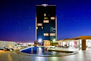 Una piscina al aire libre, sillones reclinables de piscina