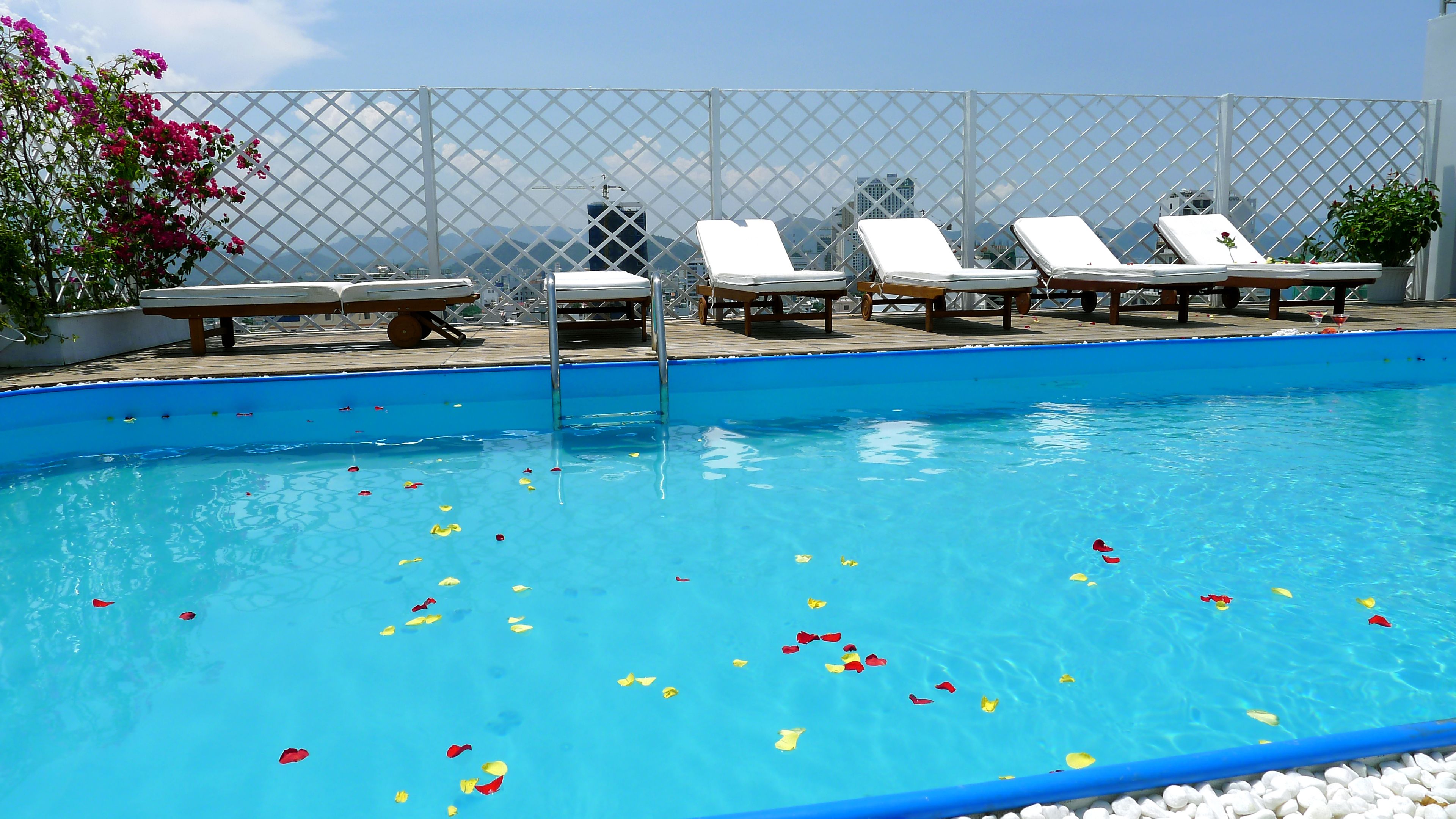 Outdoor pool, a rooftop pool, pool umbrellas, pool loungers