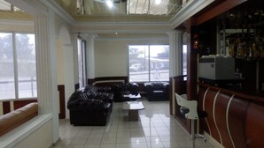 Una sala de estar con un conjunto de sofá, una mesa de centro y una zona de bar con estantes.