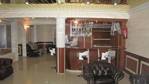 Un vestíbulo con mostrador de recepción, zona de bar y asientos.