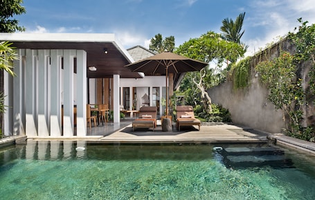 Una piscina al aire libre, sillones reclinables de piscina