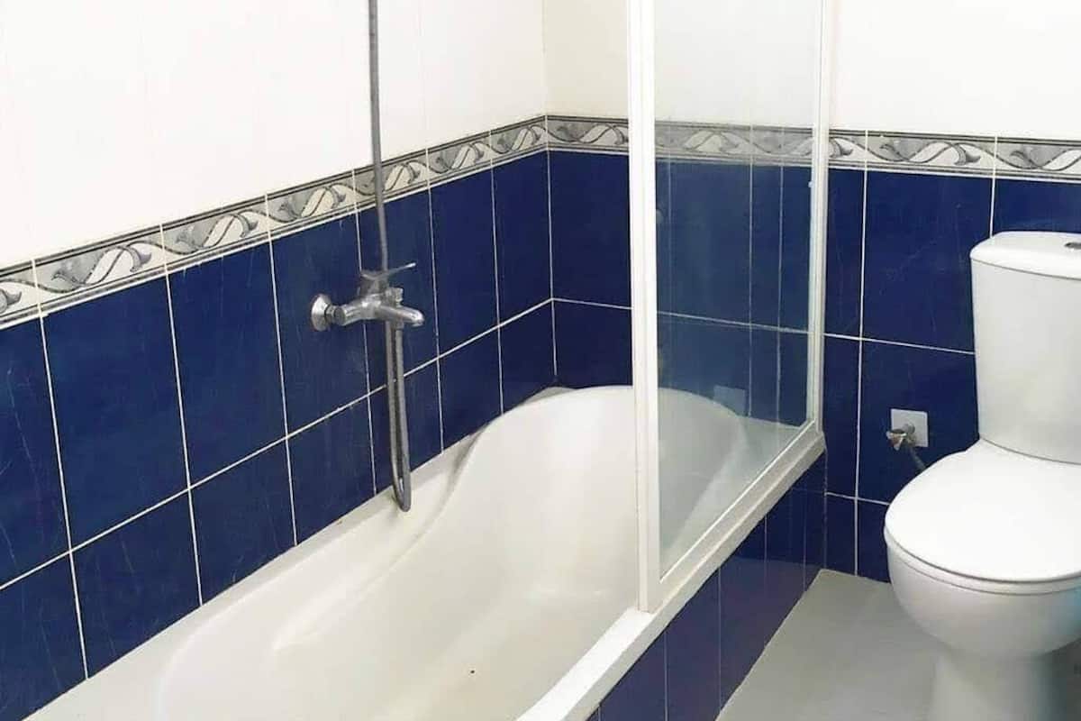 A bathroom with a bathtub, a toilet, and a shower enclosure.