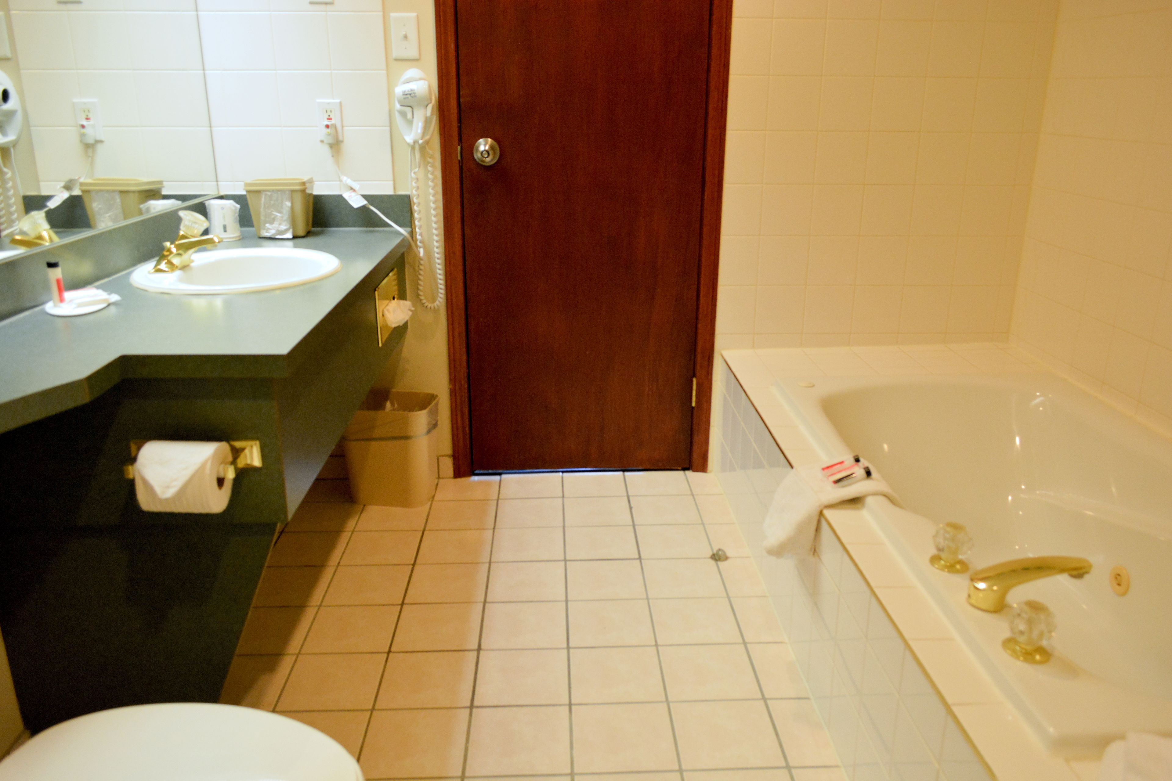 A bathroom with a sink, mirror, toilet, and bathtub.