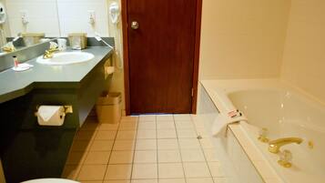 A bathroom with a sink, mirror, toilet, and bathtub.