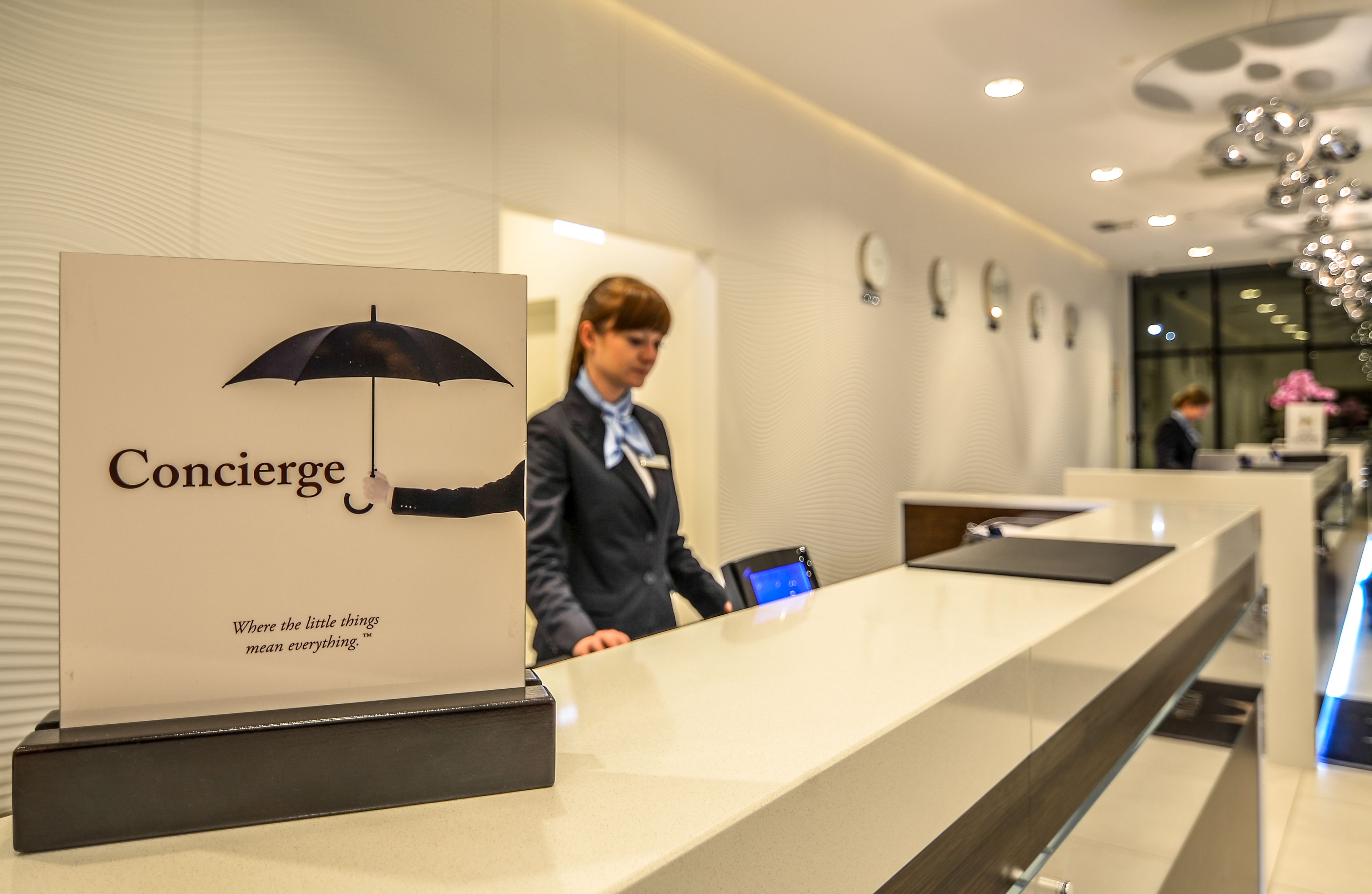 Un mostrador de recepción con un letrero que dice "Concierge" y un gráfico de paraguas.