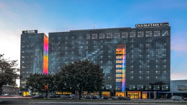 Un hotel moderno con un llamativo letrero que dice "TOYA" y la marca "DOUBLETREE BY HILTON".