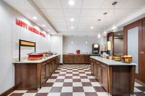 A modern kitchen with a checkered floor, wooden cabinets, and a breakfast bar. - Hampton Inn Uvalde (Uvalde)