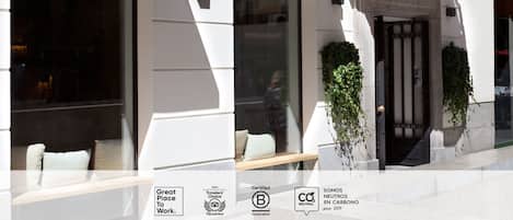 A Sleep'n'Go hotel with a modern facade, large windows, and a bench outside.