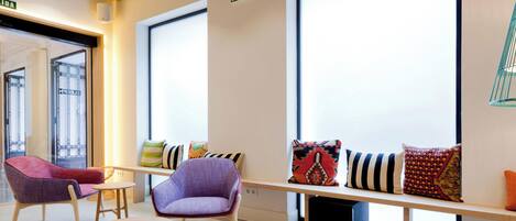 A modern lounge area with comfortable seating, a coffee table, and a view of the outside.