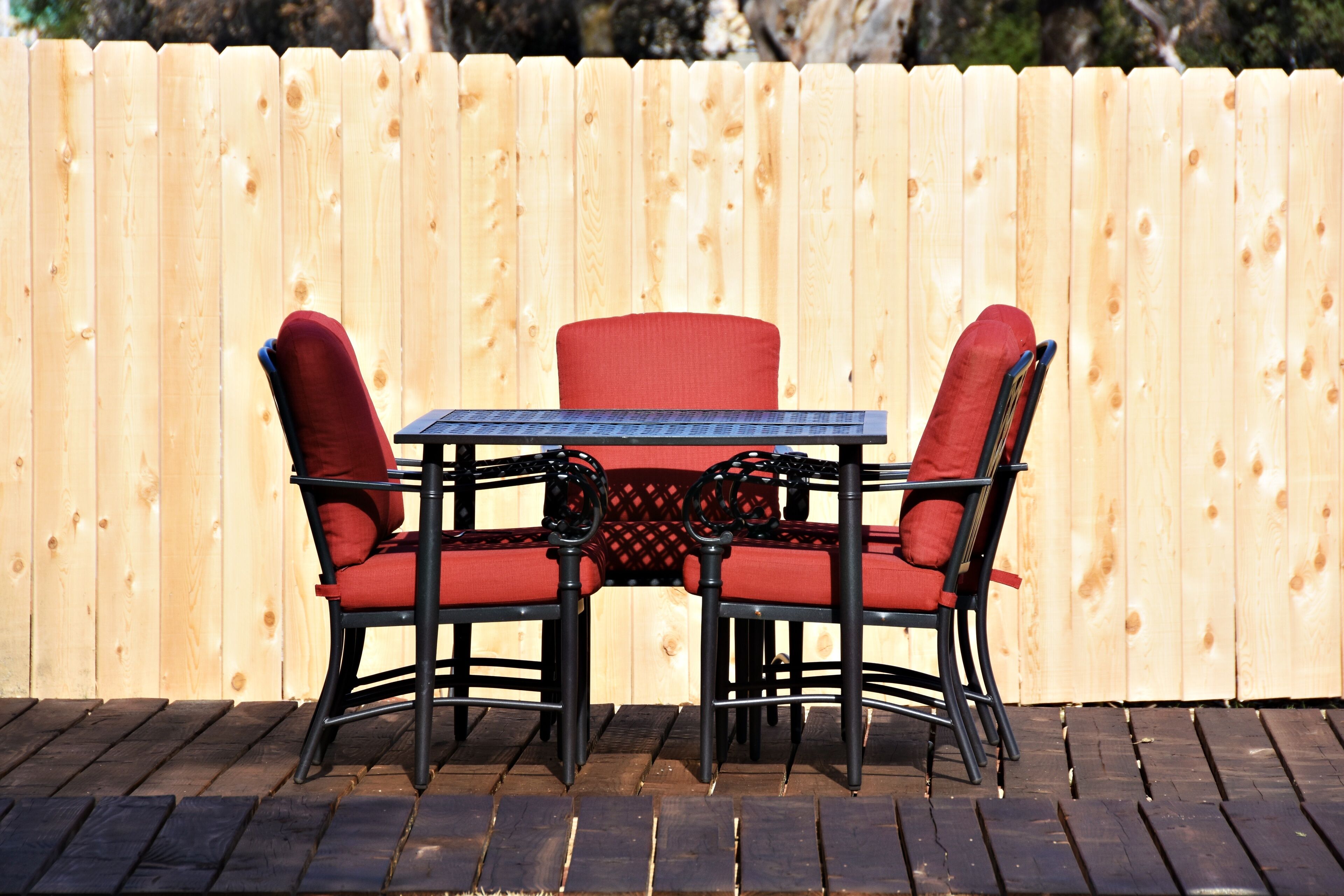 Una terraza de madera con una mesa y cuatro sillas.