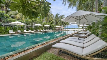 Una piscina al aire libre, sillones reclinables de piscina