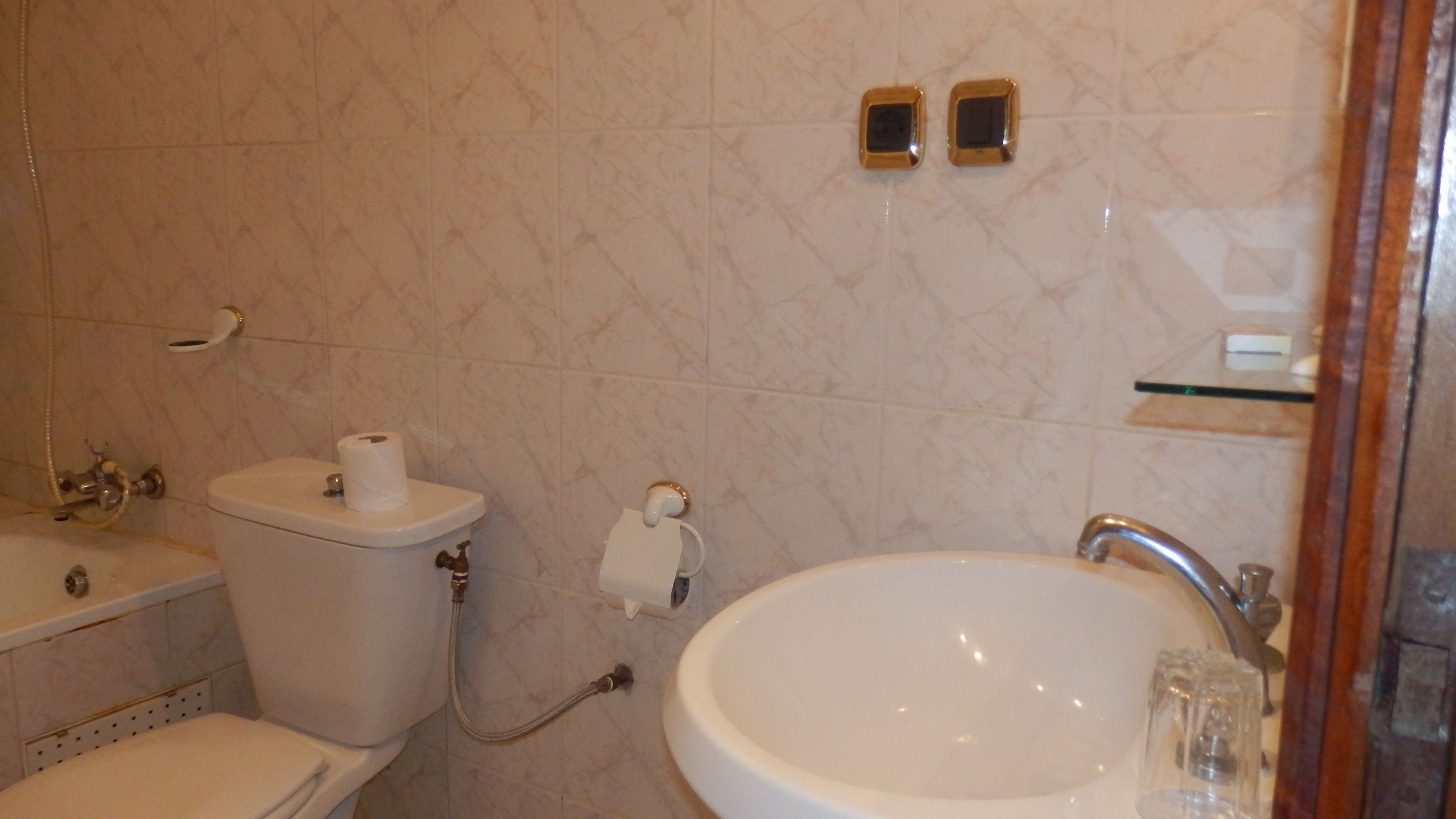 A bathroom with a toilet, sink, and shower.