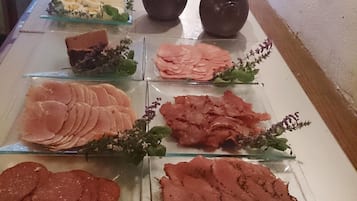 A buffet with various meats and cheeses.