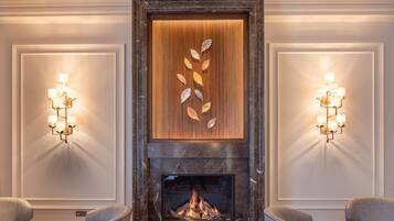 A fireplace with a modern design, flanked by two wall sconces with light fixtures.