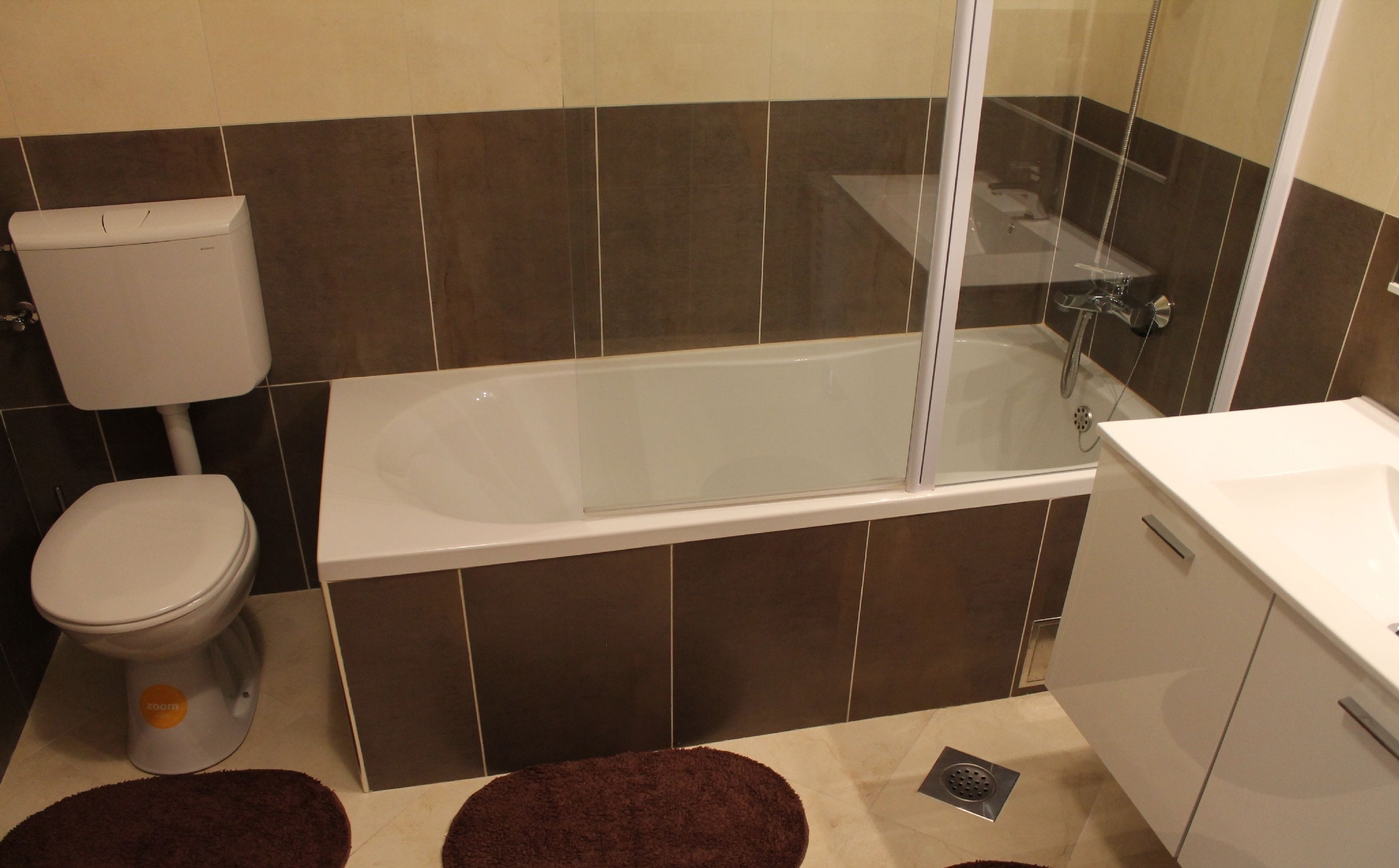Une salle de bain équipée de toilettes, d’une baignoire et d’un espace douche.