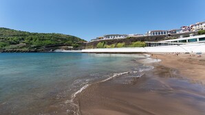 A coastal area with buildings on a hillside overlooking a beach. - Angra Marina Hotel (Angra do Heroismo)