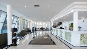A spacious lobby with a central seating area, a reception desk, and large windows offering views. - Angra Marina Hotel (Angra do Heroismo)