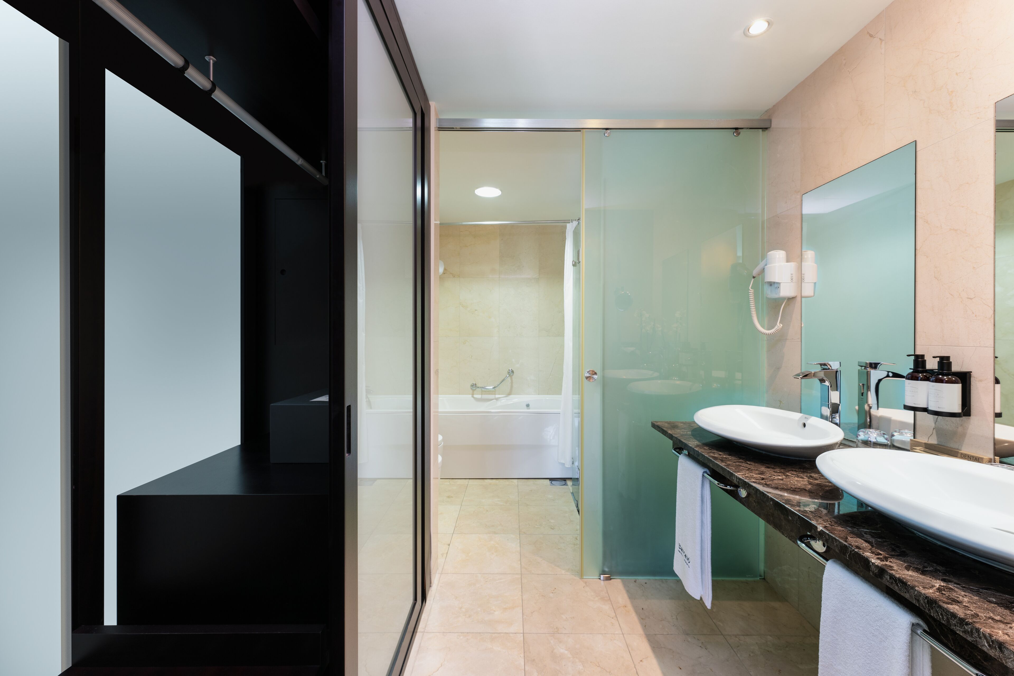 Un bagno moderno con cabina doccia in vetro, una vasca da bagno e un mobile doppio lavabo.