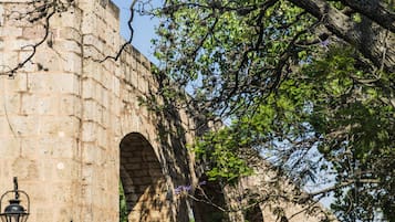 A stone bridge with arches and a street lamp.