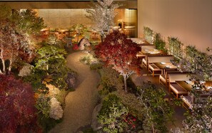 A restaurant with outdoor seating surrounded by a garden path and various plants. - Nobu Hotel Palo Alto (Palo Alto)