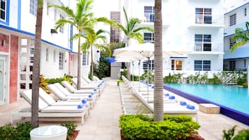 Alberca al aire libre, sombrillas en la alberca y camastros