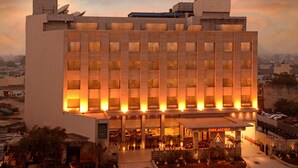 A hotel with a modern design, featuring a central courtyard with a fountain, multiple floors, and a prominent entrance labeled "Park Ascent." - Park Ascent (Noida)