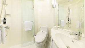 Een moderne badkamer met een douchecabine van glas, een toilet en een wastafel met grote spiegel.