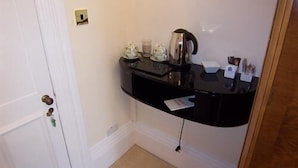 A small kitchenette with a coffee maker, tea set, and a trash bin. - The Hollies (Bridlington)