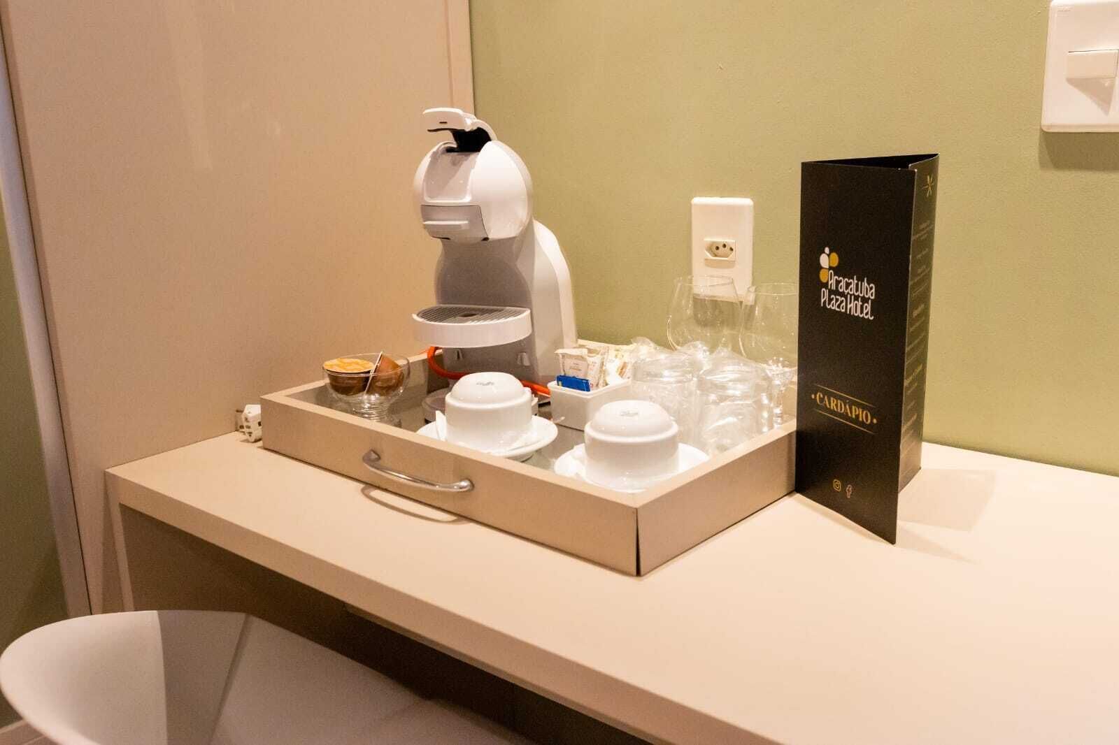 A hotel minibar with a coffee maker, tea bags, and a box of toiletries.