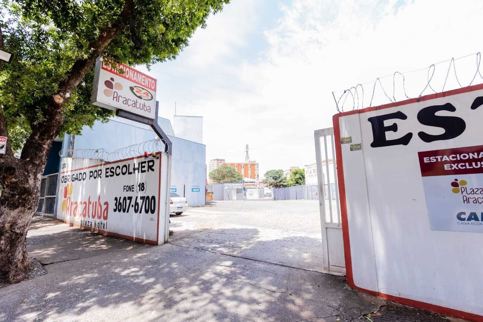 Una entrada con portón y un letrero que indica 'Plaza Aracatuba' y un número de contacto.