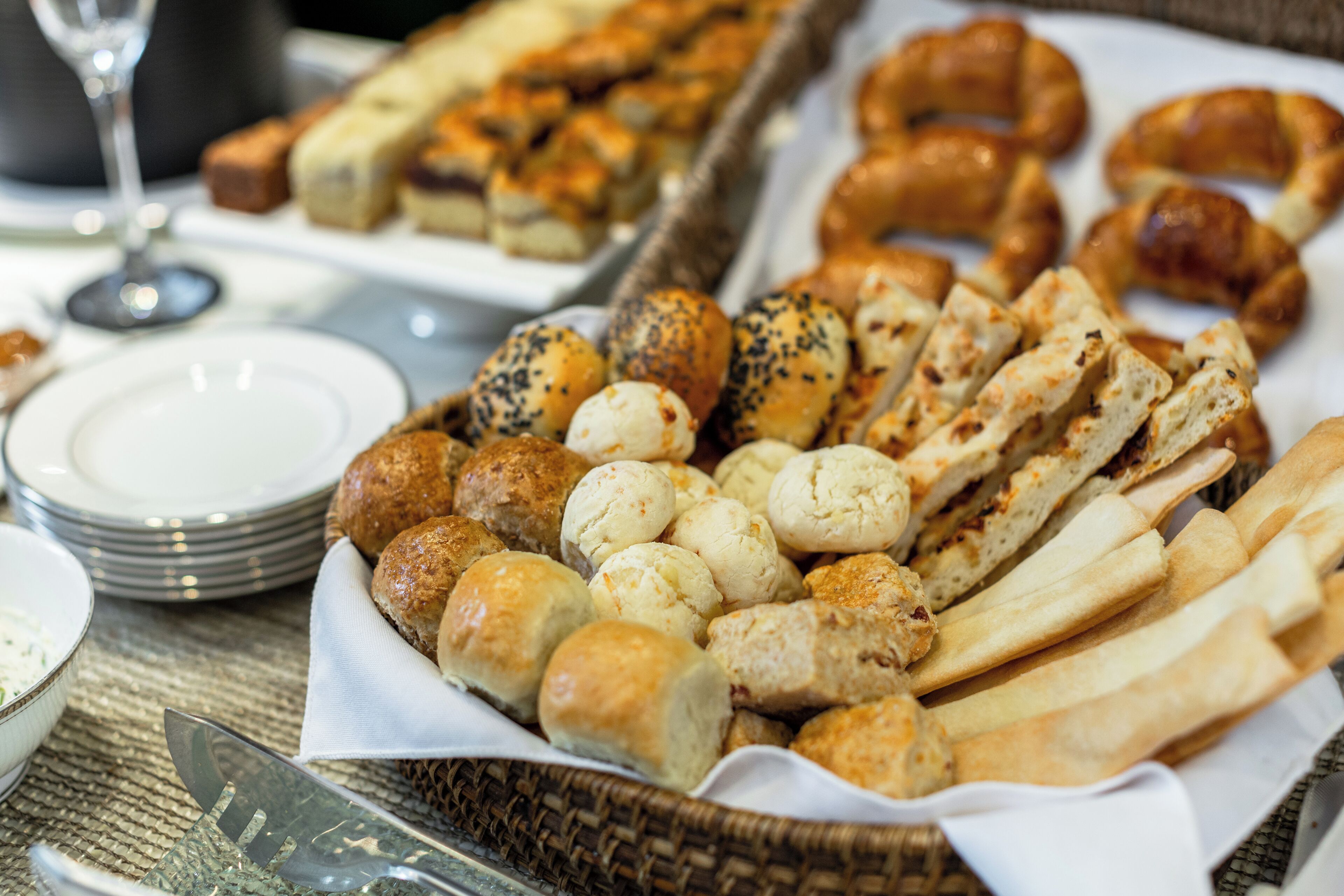 A variety of baked goods including bread rolls, croissants, and pastries on a table.