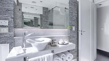 A modern bathroom with a white sink, mirror, and towel rack.
