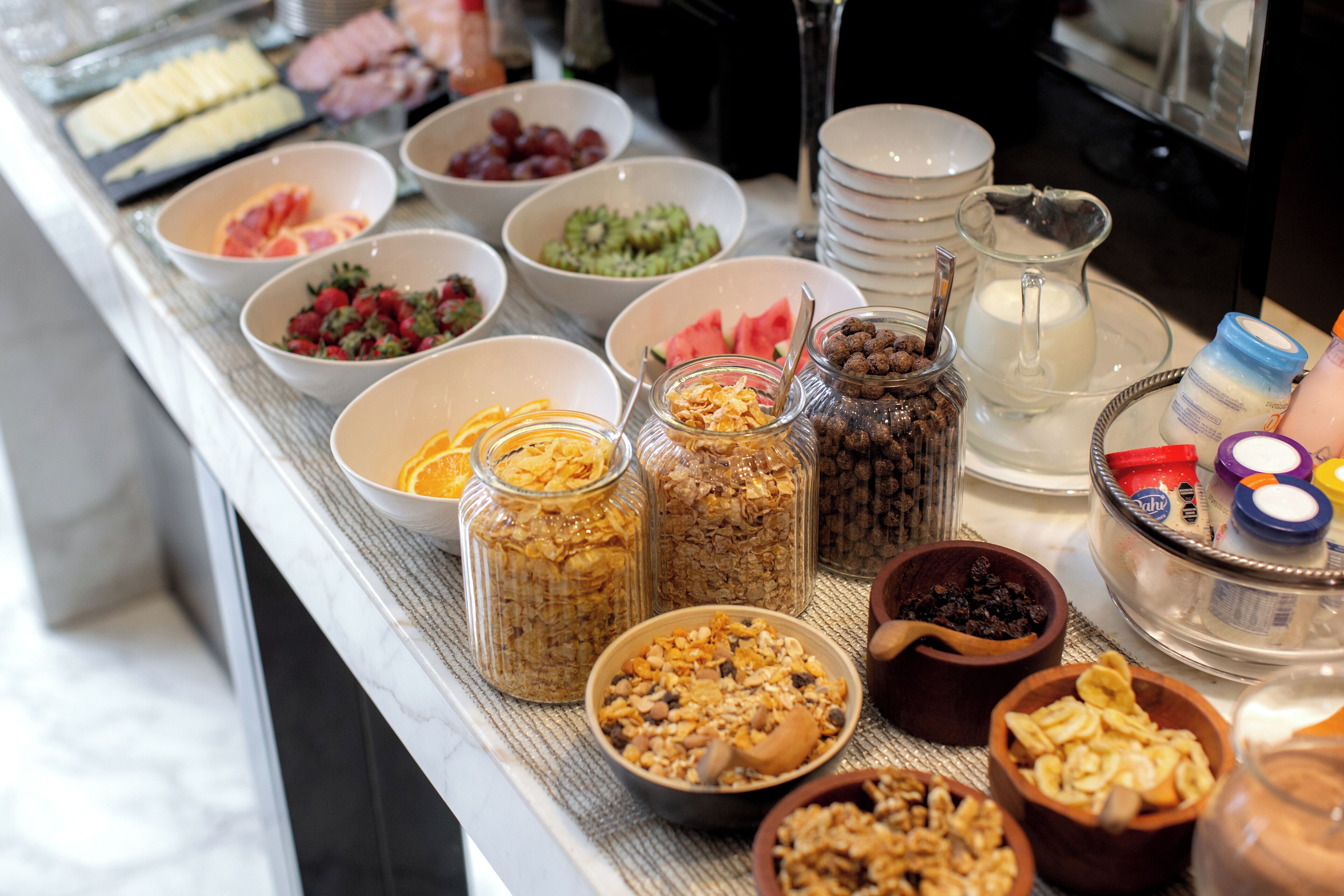 Ein reichhaltiges Buffet mit verschiedenen Speisen, darunter Obst, Nüsse und Getreide.