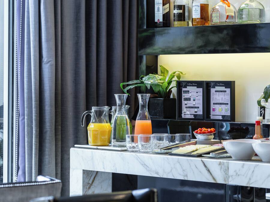 Eine Bar mit Marmorplatte, verschiedenen Flaschen, Gläsern und einer Speisekarte.
