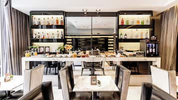 A restaurant with a bar area, marble tables, and leather chairs.