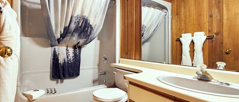 A bathroom with a bathtub, toilet, and sink.