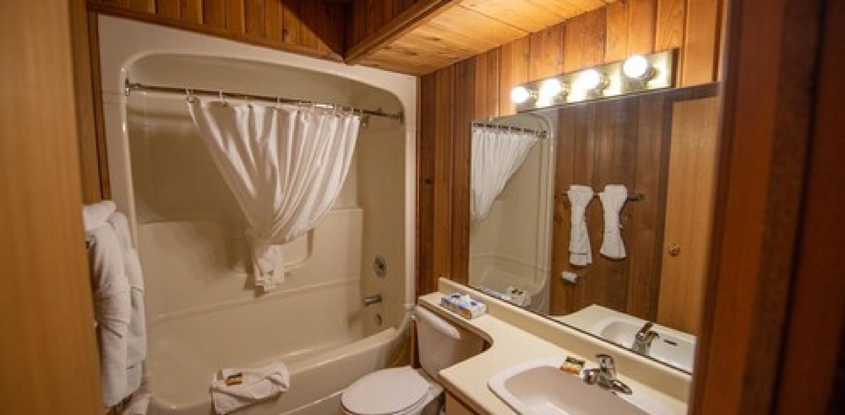 Ein Badezimmer mit Badewanne, Toilette, Waschbecken und Spiegel.