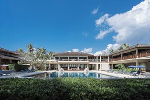 Una piscina al aire libre, sombrillas, tumbonas